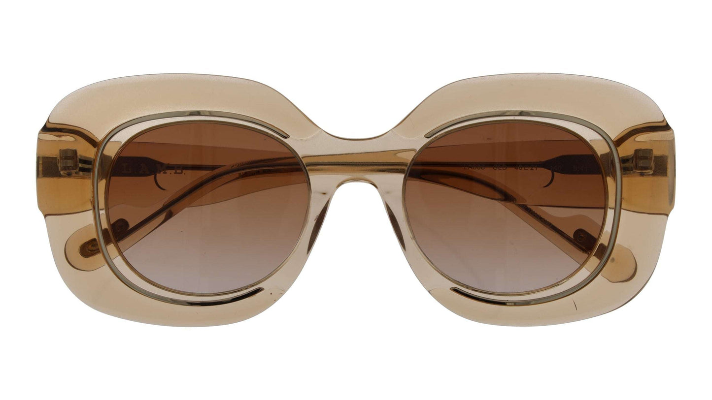 L.A.M.B. LA608 GLD Sunglasses with crystal gold frame, brown lavender fade lenses, and UV400 protection
